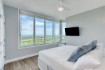 Primary Bedroom has king size bed, wall mounted television and endless views of the Bay. 